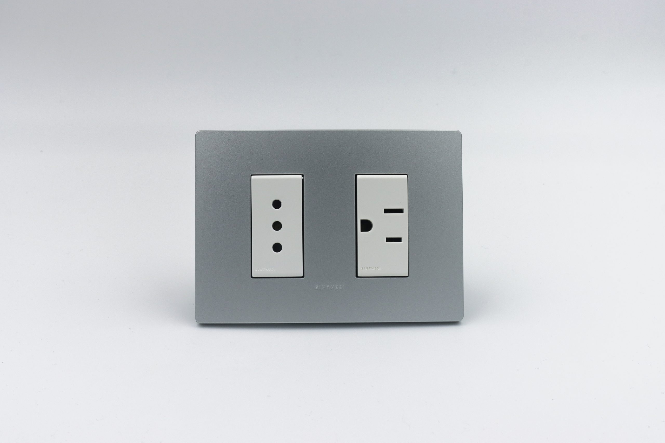 TOMACORRIENTE DOBLE ( 01 DE 3 EN LINEA + 01 AMERICANO) S33 PLACA PLATA Y DADOS S22 BLANCOS SINTHESI